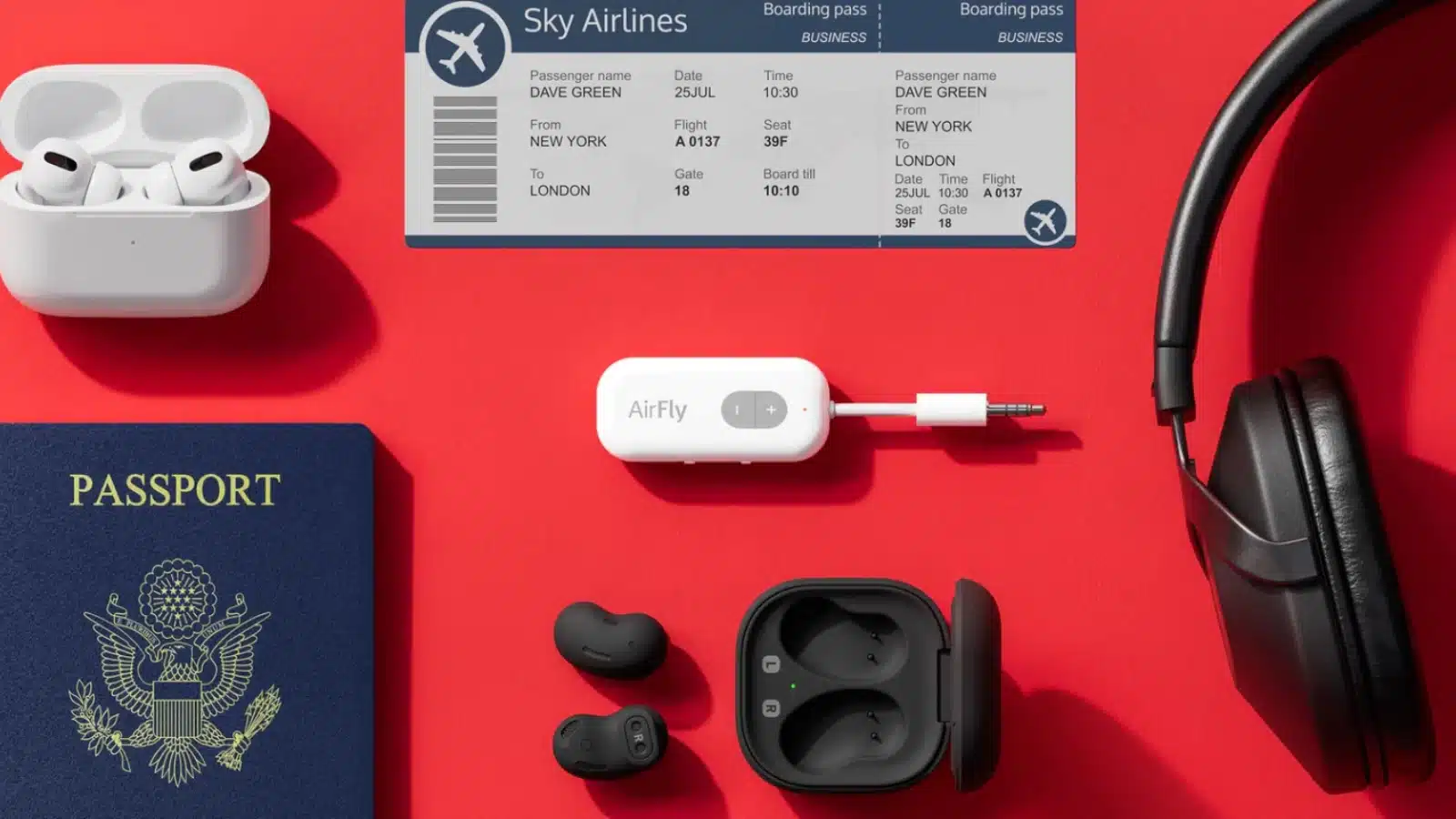 airfly inflight bluetooth adapter next to a passport and several pairs of headphones